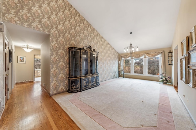 unfurnished living room with light wood-type flooring and a notable chandelier