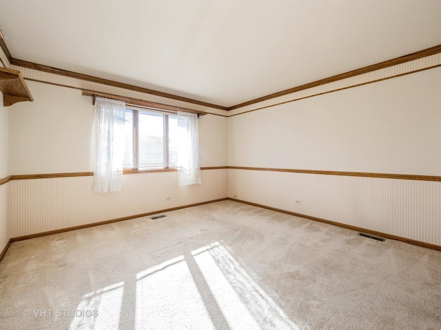 empty room with light carpet and crown molding