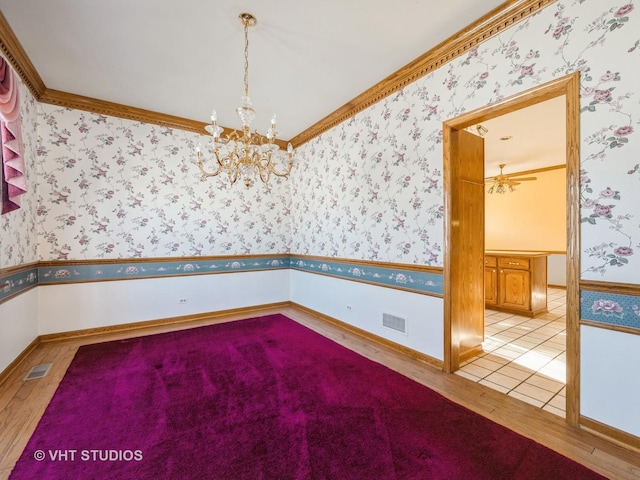 empty room with light hardwood / wood-style floors, crown molding, and ceiling fan with notable chandelier