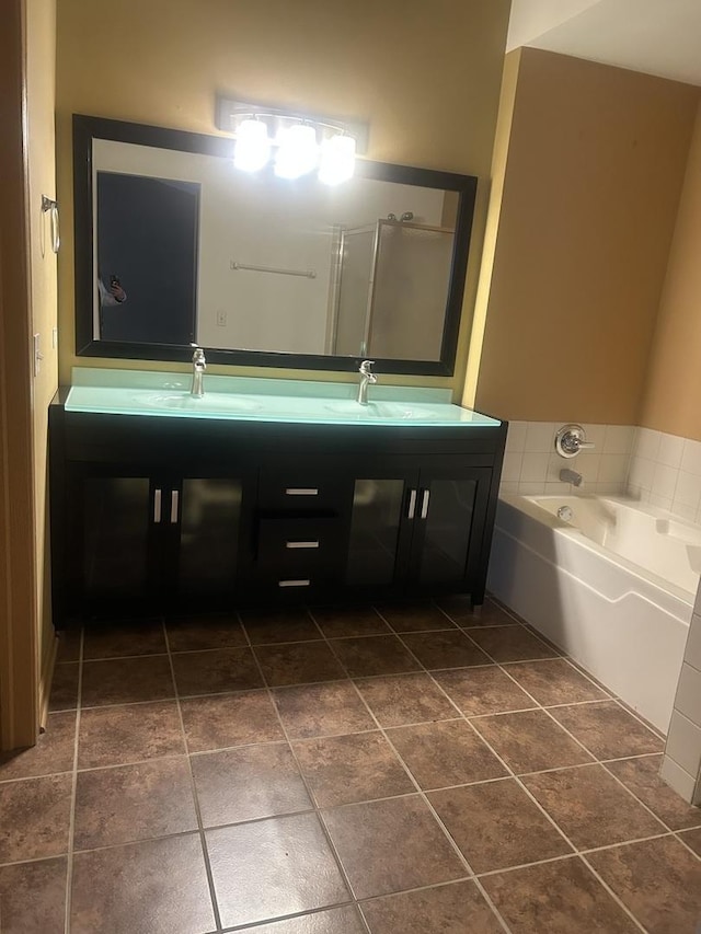 bathroom with tile patterned flooring, a bathtub, and vanity