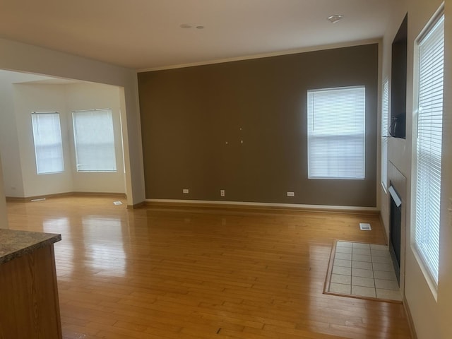 spare room with light hardwood / wood-style flooring and crown molding