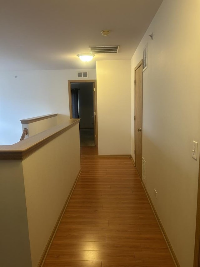 corridor with hardwood / wood-style floors