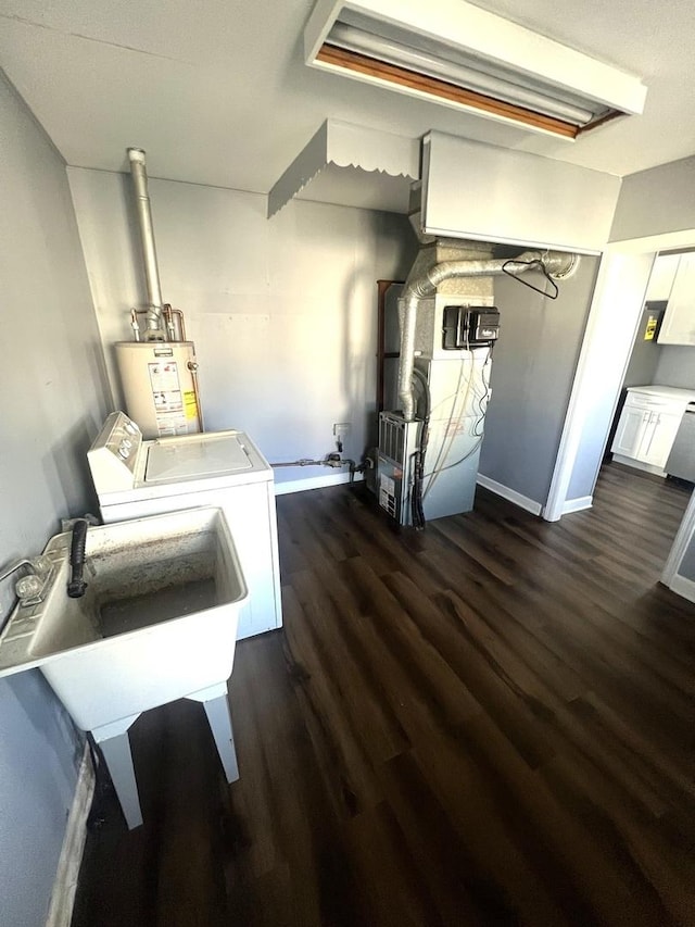 interior space featuring dark wood-style floors, gas water heater, heating unit, independent washer and dryer, and baseboards