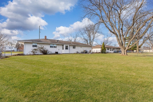 rear view of property with a yard