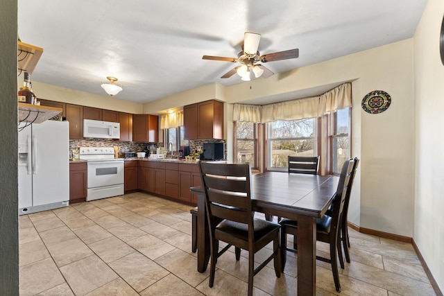 tiled dining area featuring ceiling fan and sink