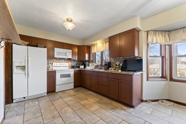 kitchen featuring white appliances, tasteful backsplash, plenty of natural light, and sink