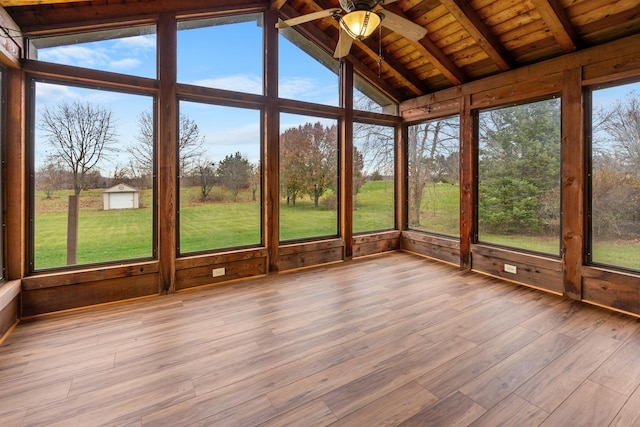 unfurnished sunroom featuring wood ceiling, ceiling fan, plenty of natural light, and lofted ceiling with beams