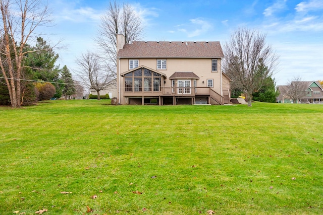 back of house with a sunroom, a wooden deck, and a lawn