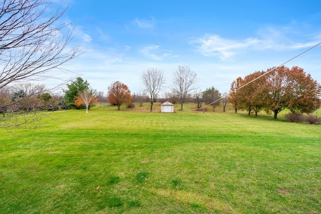 view of yard with a rural view and a storage shed