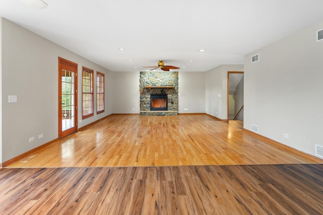 unfurnished living room featuring a fireplace, light wood-type flooring, and ceiling fan