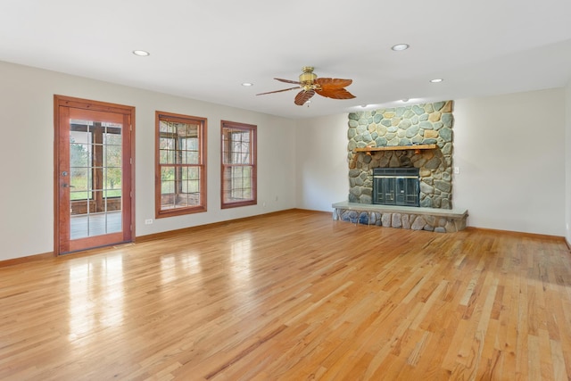 unfurnished living room with ceiling fan, light wood-type flooring, and a fireplace