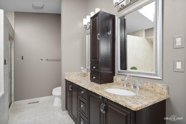 bathroom with toilet, tile patterned floors, a shower with shower door, and vanity