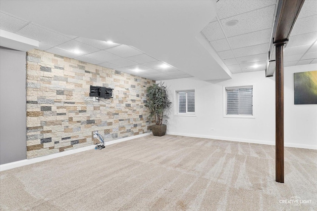 basement featuring light colored carpet and a paneled ceiling