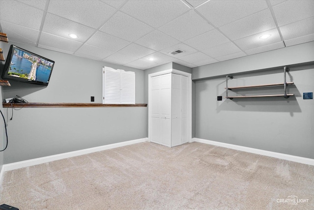 basement with carpet flooring and a drop ceiling