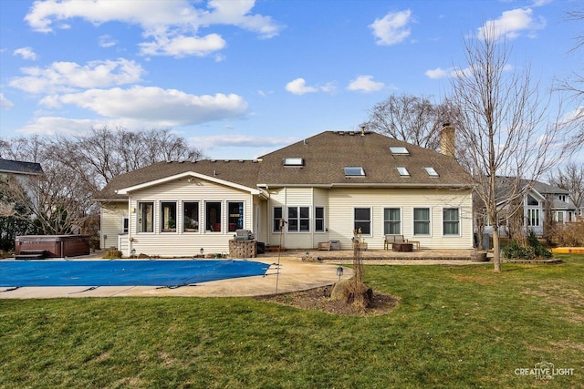 back of property featuring a yard, a hot tub, and a patio