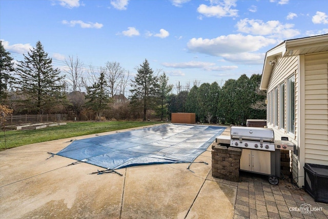 view of pool with a lawn, a grill, and a patio