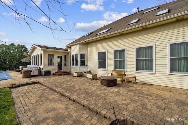 back of house featuring an outdoor fire pit and a patio area