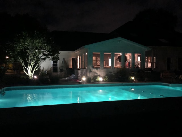 view of pool at twilight