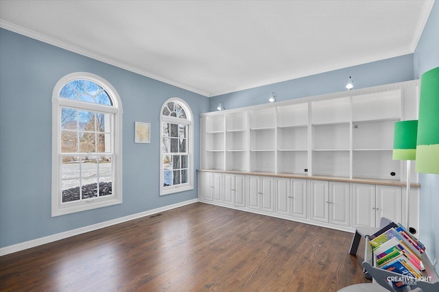 spare room with ornamental molding and dark wood-type flooring