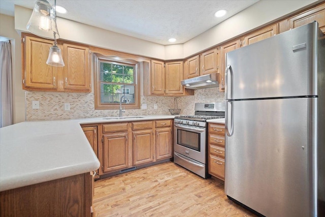 kitchen with pendant lighting, stainless steel appliances, tasteful backsplash, and sink