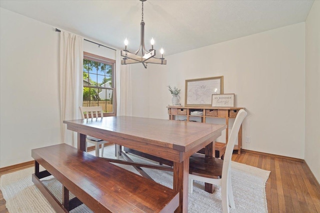 dining area featuring hardwood / wood-style floors and a chandelier