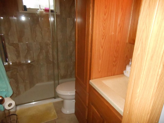 bathroom featuring tile patterned floors, toilet, and an enclosed shower