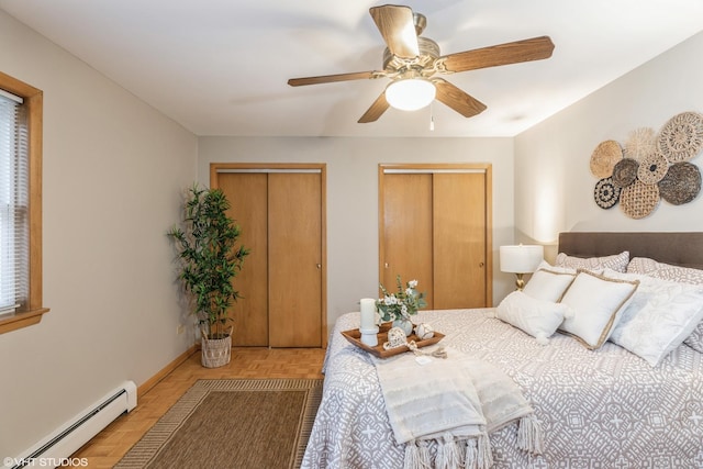 bedroom featuring parquet floors, two closets, a baseboard radiator, and ceiling fan