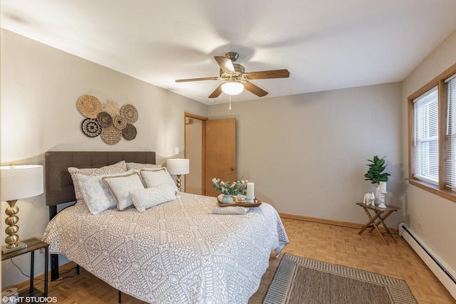 bedroom with ceiling fan, parquet floors, and a baseboard heating unit