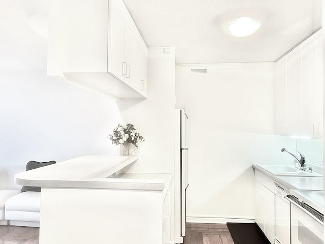 kitchen with sink, white cabinets, white dishwasher, and range