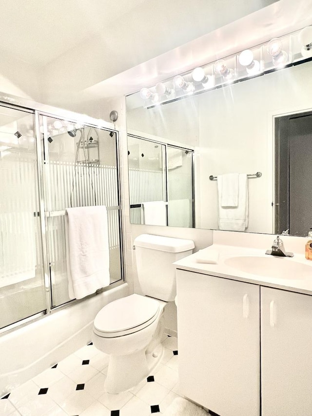 full bathroom featuring tile patterned flooring, vanity, bath / shower combo with glass door, and toilet