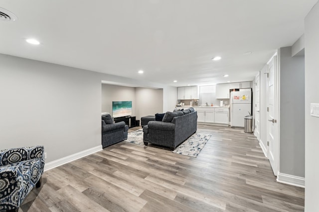 living room with light hardwood / wood-style floors and sink