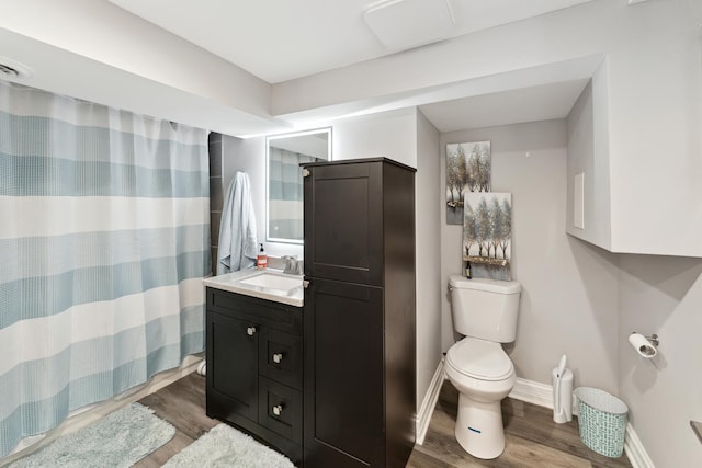 bathroom featuring walk in shower, toilet, vanity, and hardwood / wood-style flooring