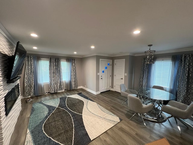 living room with dark hardwood / wood-style floors, crown molding, and an inviting chandelier