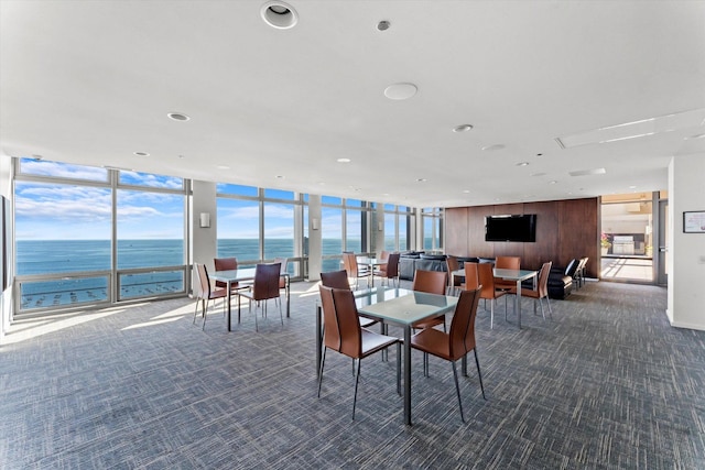 carpeted dining room featuring a water view