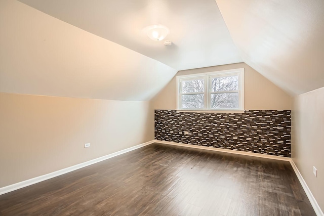 additional living space featuring dark hardwood / wood-style flooring and lofted ceiling