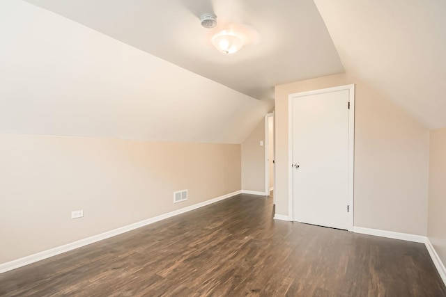 bonus room with dark hardwood / wood-style floors and vaulted ceiling