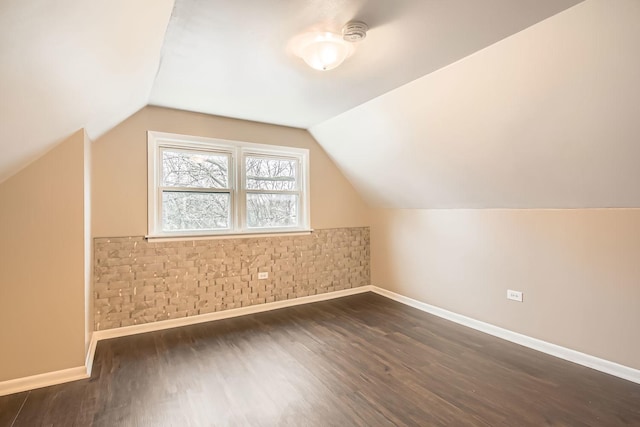 bonus room with dark wood-type flooring and lofted ceiling