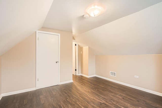 bonus room with dark wood-type flooring and lofted ceiling