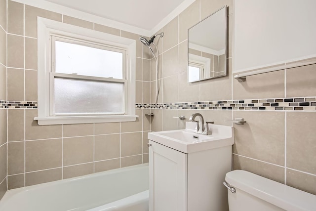 full bathroom with tiled shower / bath, vanity, toilet, and tile walls