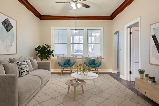 living room featuring hardwood / wood-style floors, ceiling fan, and crown molding