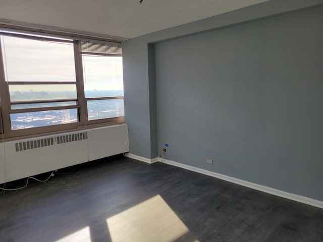 spare room with radiator heating unit and a water view