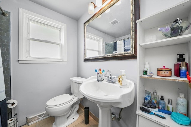 bathroom featuring toilet and curtained shower