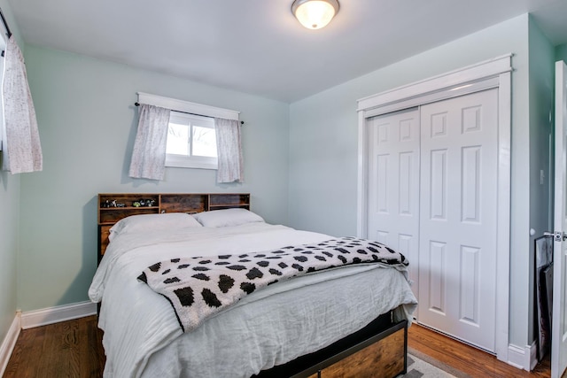 bedroom with dark hardwood / wood-style flooring and a closet