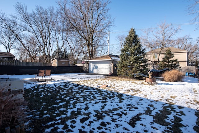 yard covered in snow with a garage and an outbuilding