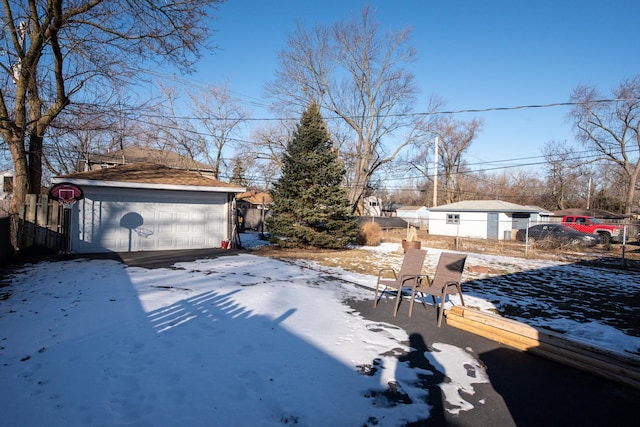 snowy yard with an outbuilding and a garage