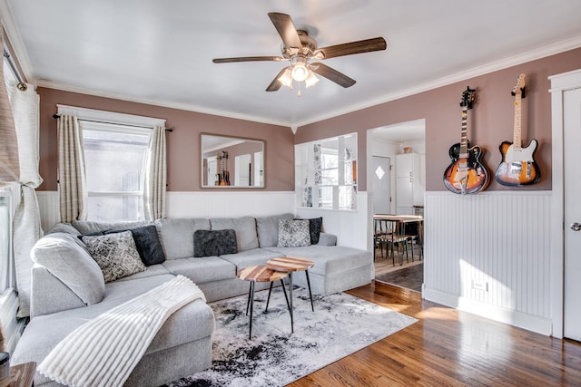 living room with hardwood / wood-style floors, ornamental molding, and ceiling fan