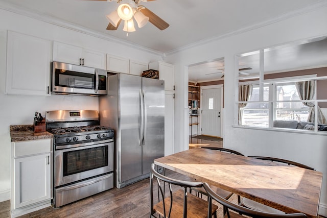 kitchen featuring dark wood-type flooring, appliances with stainless steel finishes, crown molding, and white cabinets