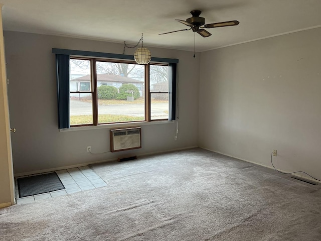 unfurnished room with ceiling fan, light colored carpet, and heating unit