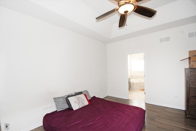 bedroom featuring visible vents, ensuite bathroom, baseboards, and wood finished floors