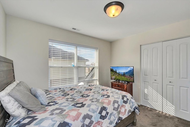 carpeted bedroom with visible vents and a closet